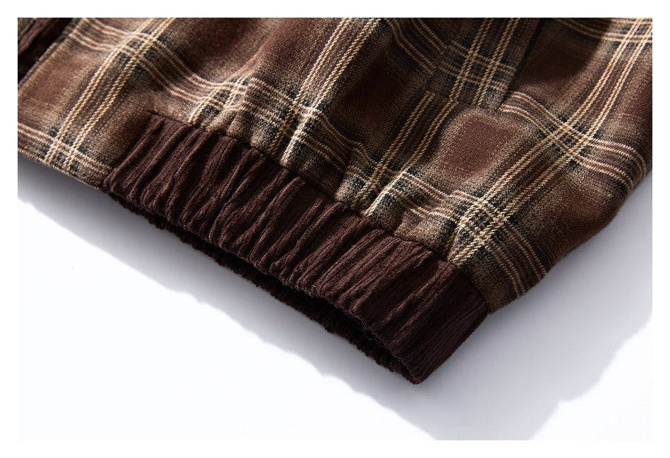 Close-up of the brown plaid garment's gathered hem with a dark brown ribbed band.