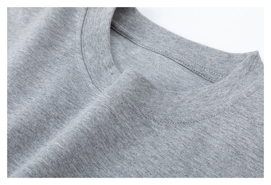 Angled close-up of the crew neckline and stitching on a heather gray shirt.