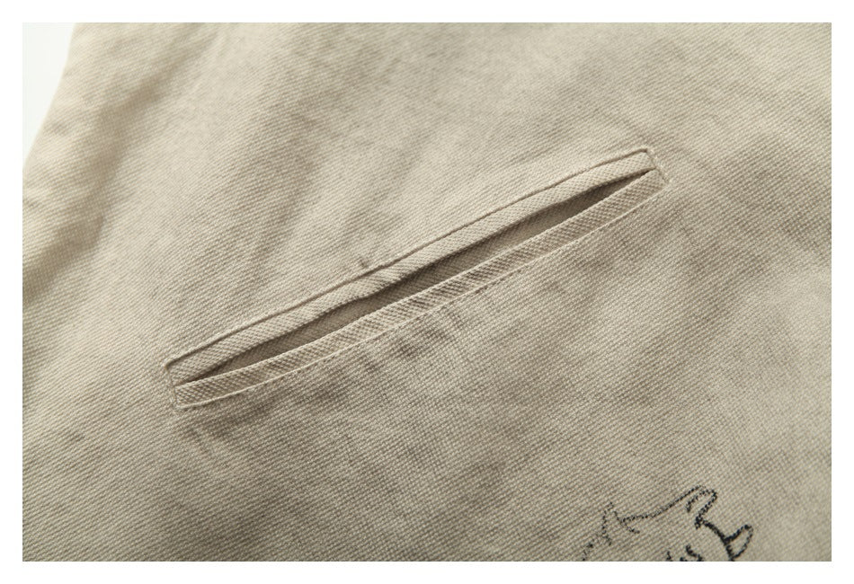 Close-up of a narrow welt pocket on beige jacket fabric.