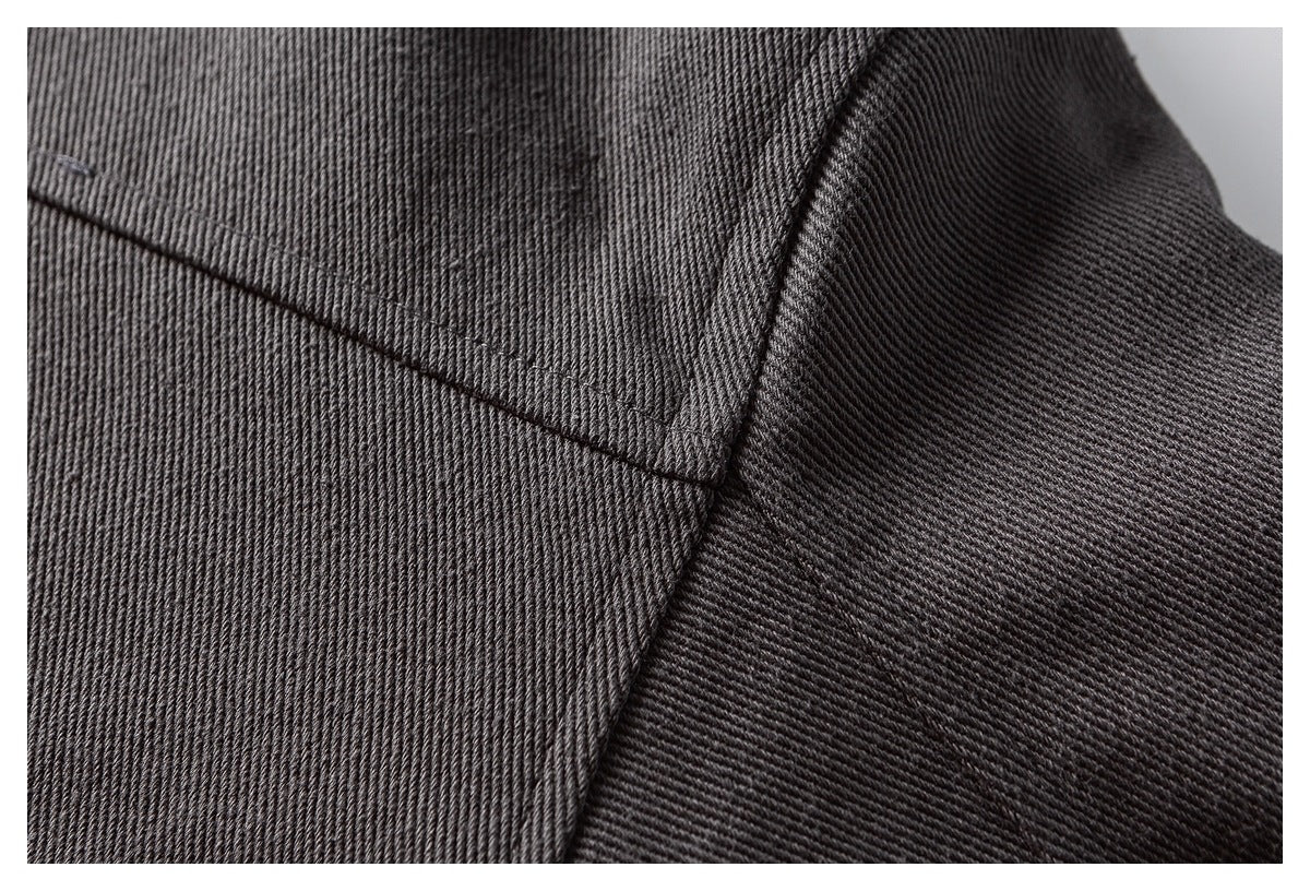 Close-up of a curved stitched seam joining panels of charcoal ribbed fabric.