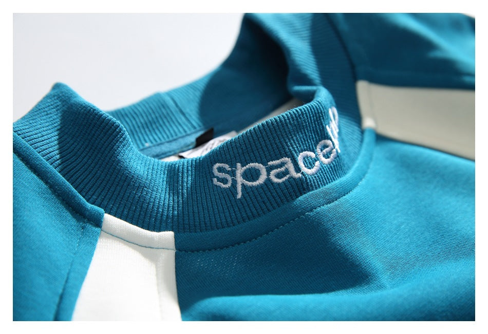 Angled close-up of the teal sweatshirt's ribbed collar with white embroidered lettering and cream paneling.