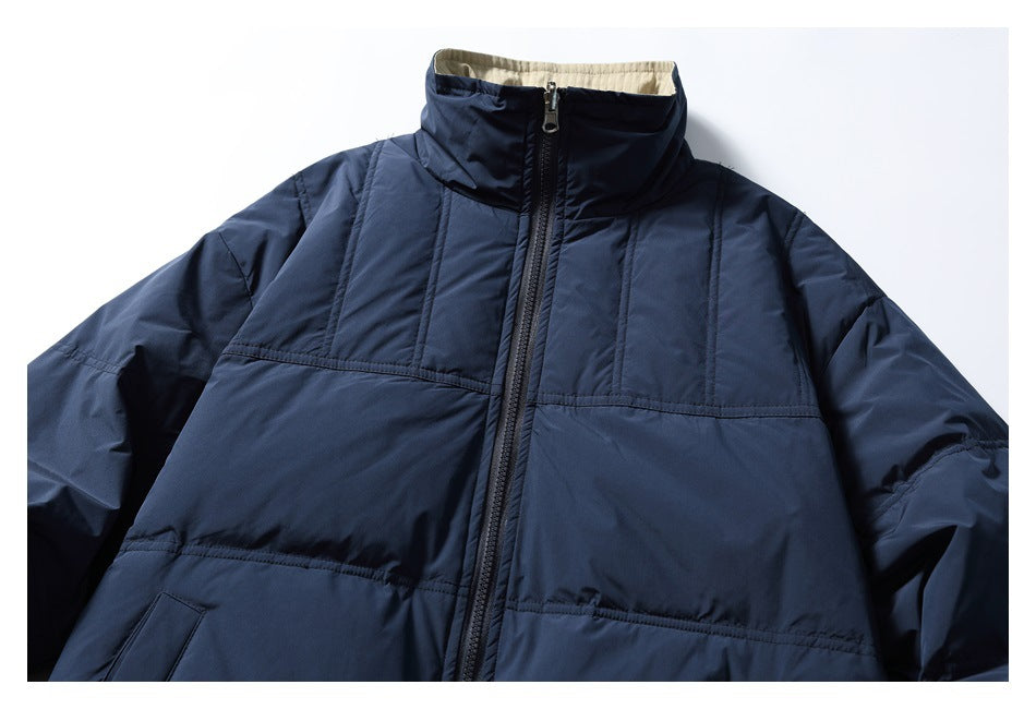 Close view of the dark navy jacket front, showing its high collar, center zipper, and stitched upper panels.