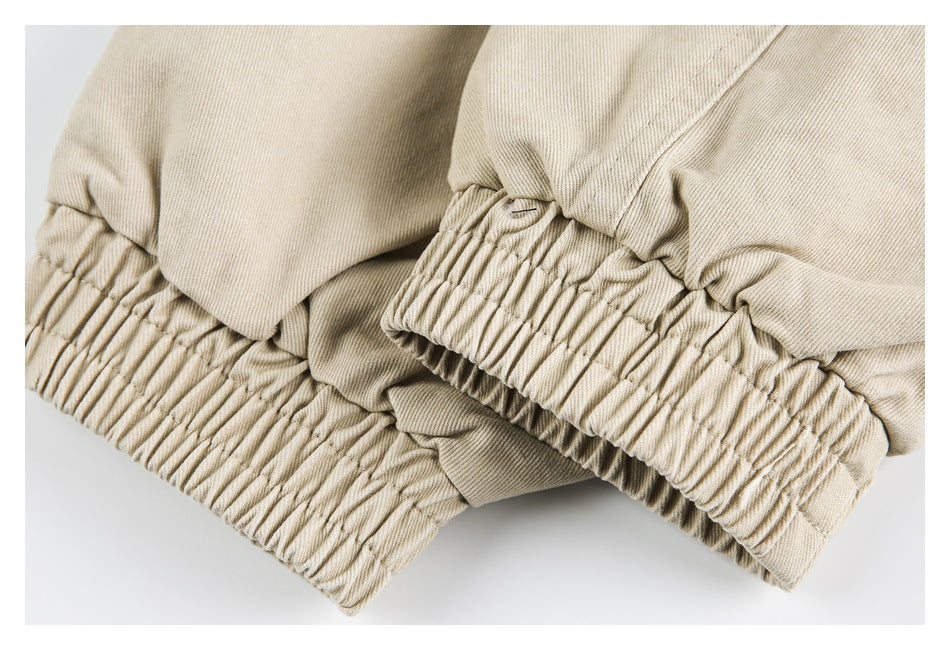 Close-up of gathered elastic trim at the hem of beige garment fabric.