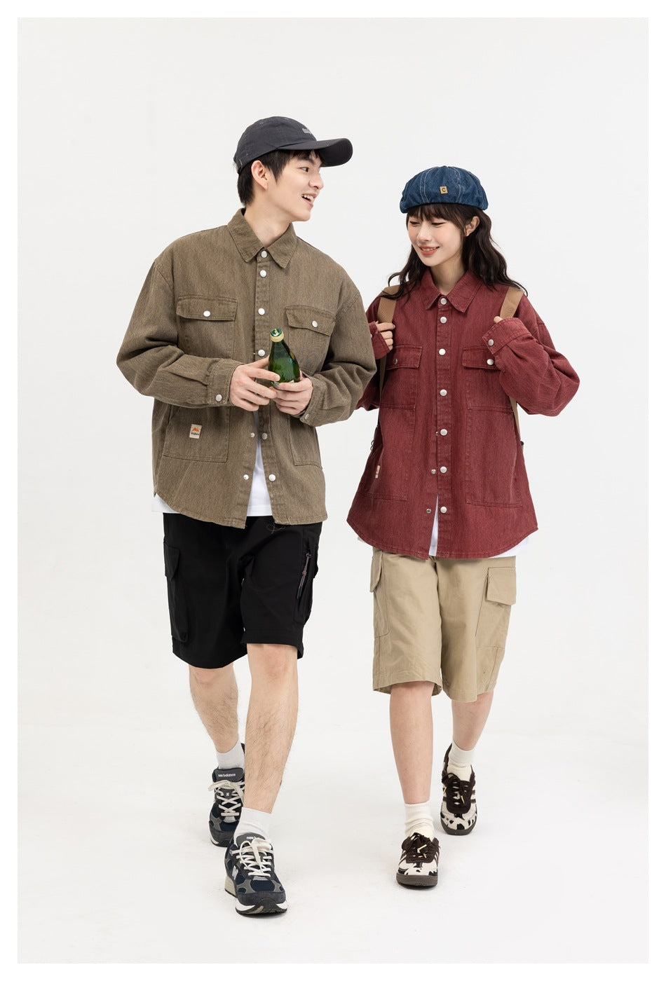 Two models walk wearing olive and burgundy button-front shirts with multiple pockets and cargo shorts.