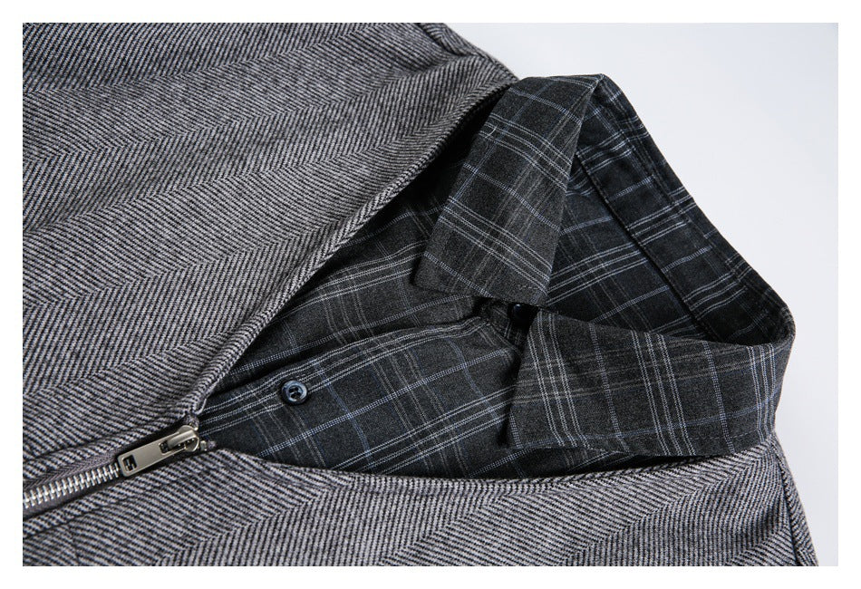 Close-up of the jacket's dark plaid inner lining and collar beneath the gray herringbone outer fabric.