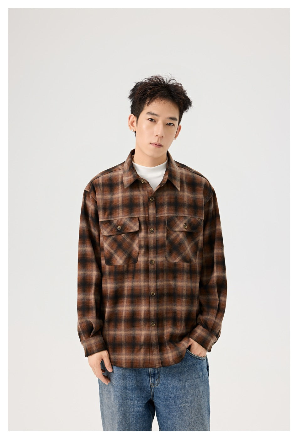 Model wearing a brown and black plaid button-up shirt with two flap chest pockets.