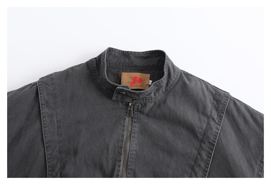 Close-up of the charcoal jacket's stand collar, front zipper, shoulder seams, and inner neck label.