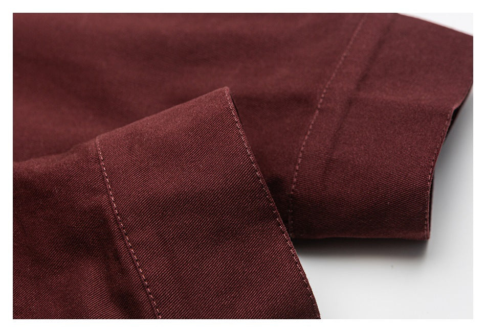 Close-up of a folded burgundy garment edge with visible stitching and seam detail.