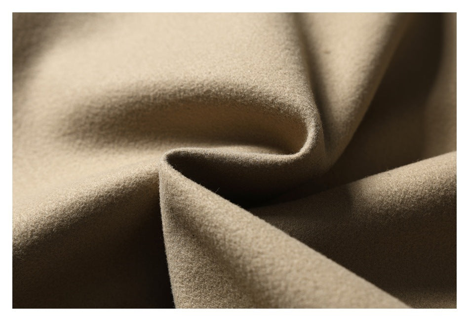 Extreme close-up of beige fabric draped into folds, showing its surface texture.