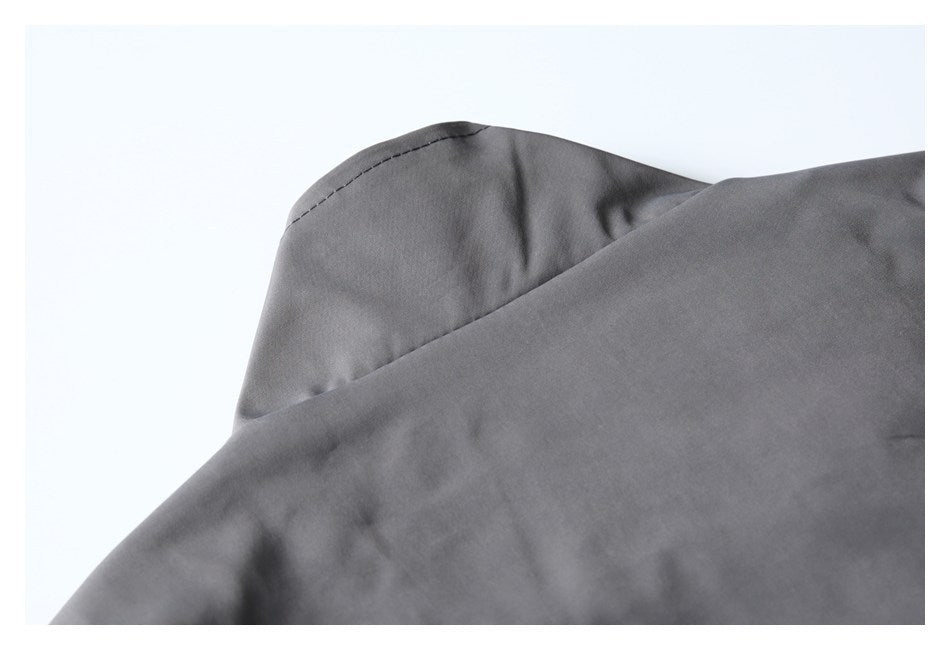 Close-up of a curved, stitched garment section in gray fabric.