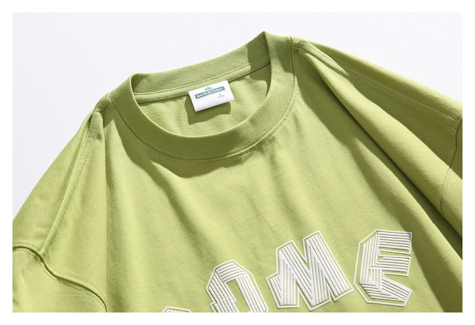 Close-up of the lime-green T-shirt collar, neck label, stitching, and part of its raised white chest lettering.