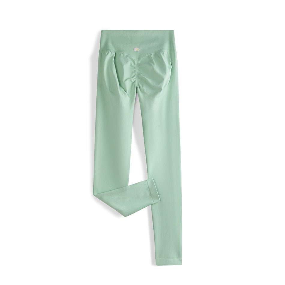 Mint green high-waisted leggings shown from the back, with a ruched seat and one leg folded to show the hem.
