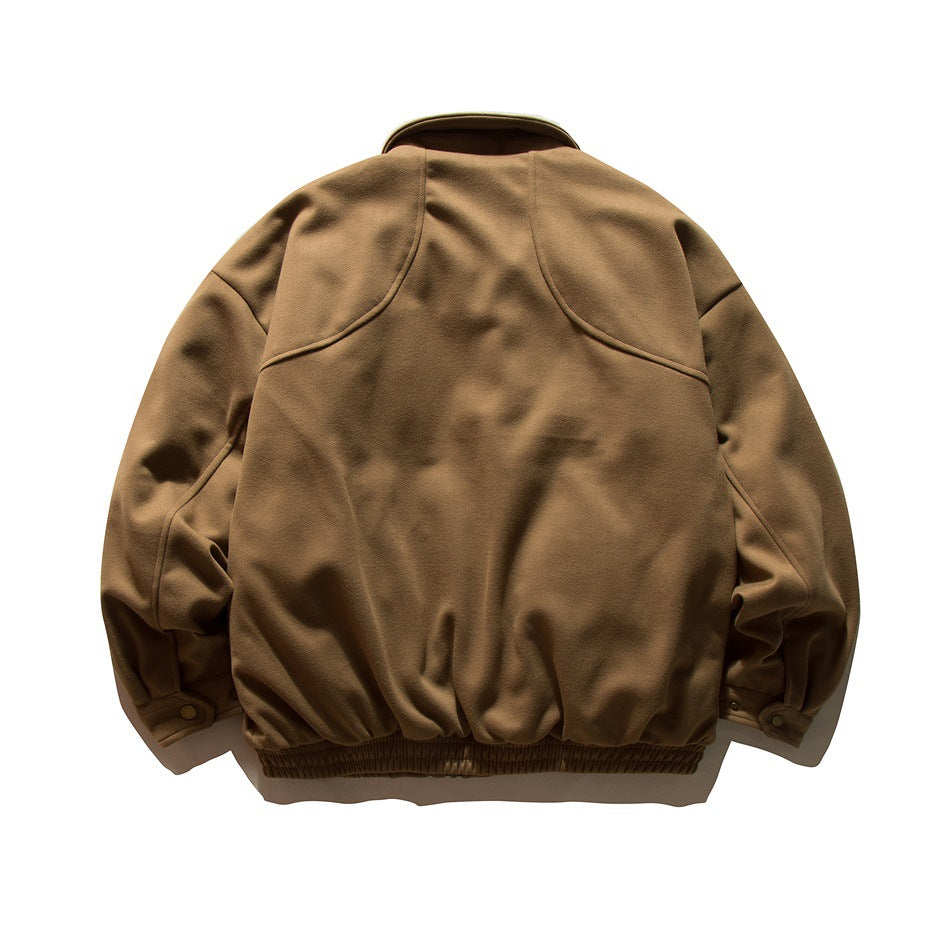 Back view of brown bomber-style jacket showing curved yoke seams, snap cuff tabs and ribbed elastic hem