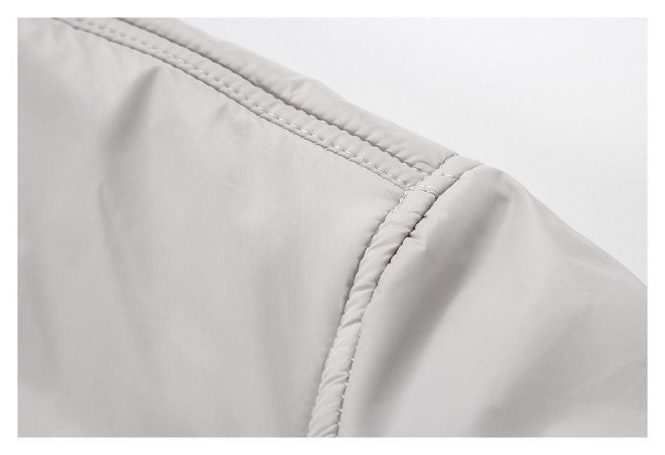 Close-up of the light gray jacket's shoulder seam and double stitching.