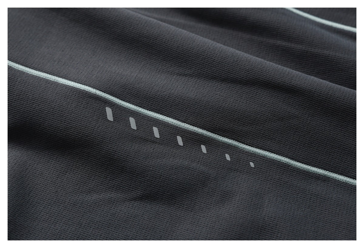 Charcoal fabric detail with pale mint piping and a row of small light-colored marks.