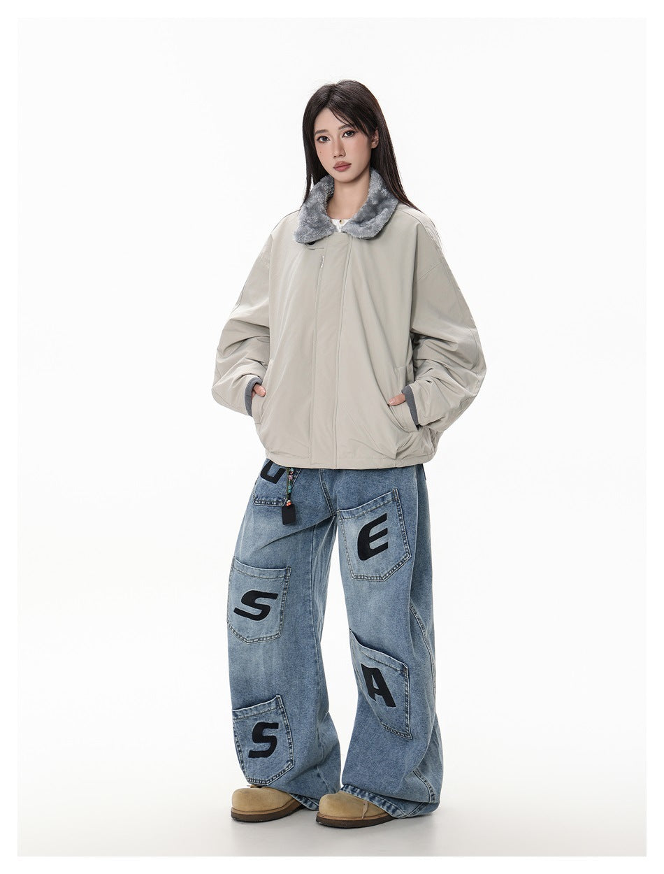 Full-length model wearing a light gray oversized jacket with a gray plush collar and wide blue jeans with black letter