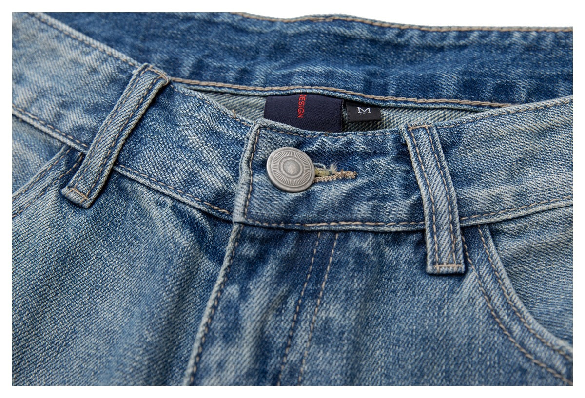 Close-up of the denim shorts' front waistband, button, belt loops and inner labels.