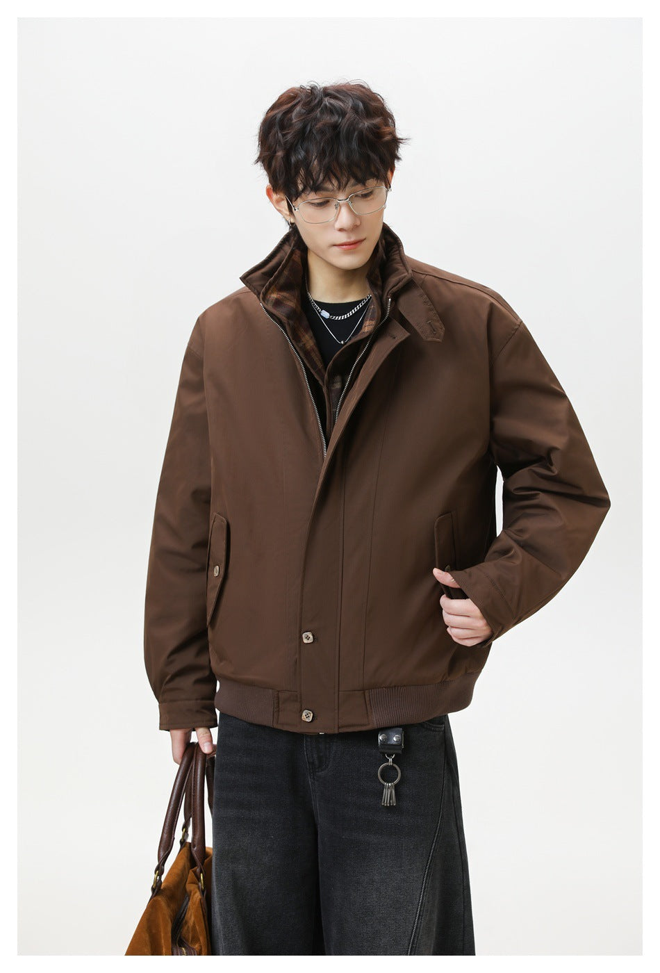 Close front view of a model wearing a brown zip-front jacket with a raised collar and ribbed hem.