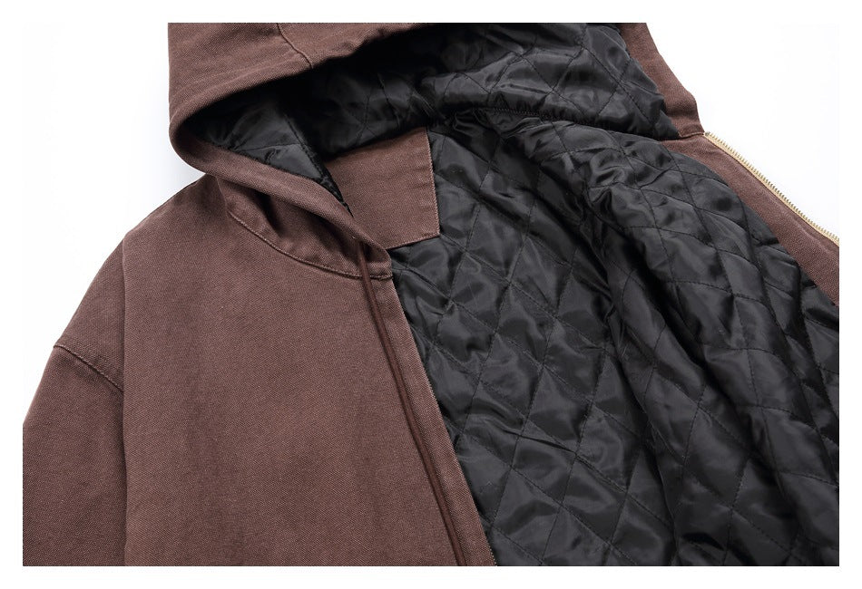 Close-up of the brown jacket opened to show its black diamond-quilted lining and zipper.