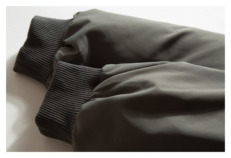 Close-up of two dark olive jacket sleeves with ribbed cuffs.