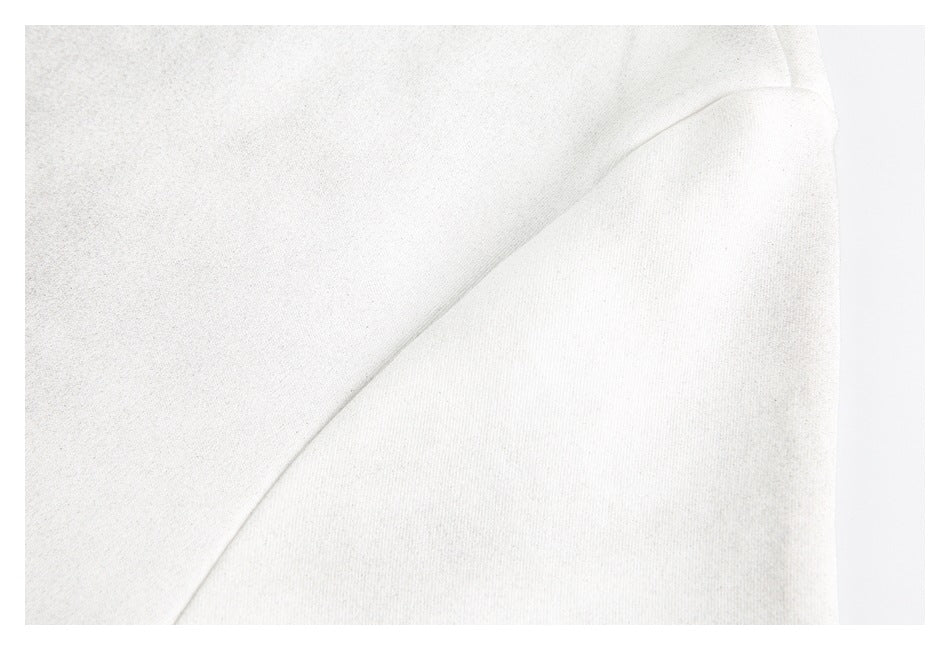 Close-up of softly folded off-white garment fabric with a curved seam.