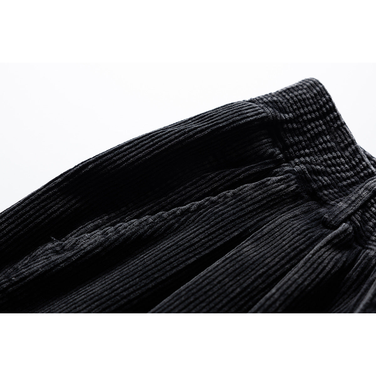Close-up of the inside waistband and ribbed fabric of black trousers.
