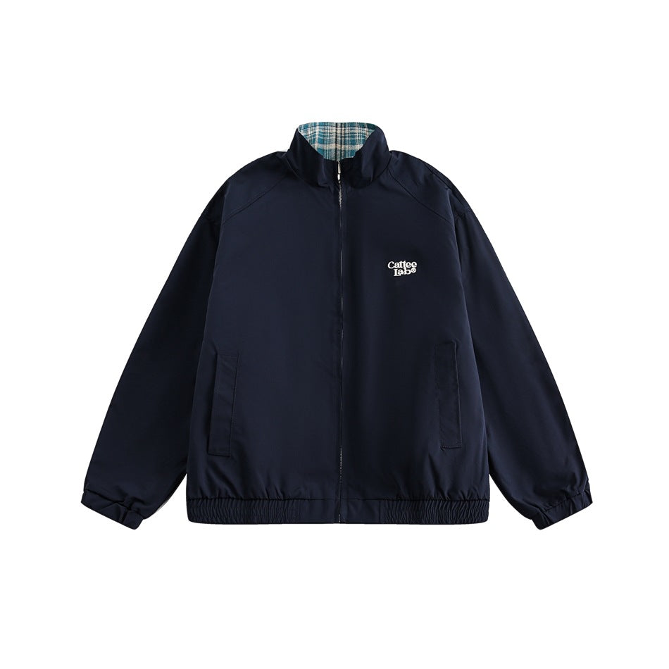 Navy zip-up stand-collar jacket flat lay with chest logo, front pockets, elastic cuffs and hem, teal plaid collar lining