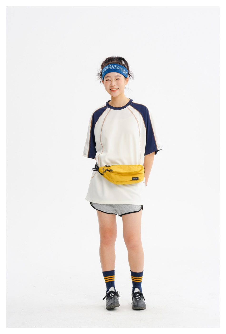 Full-length view of a model wearing an oversized ivory-and-navy raglan T-shirt.