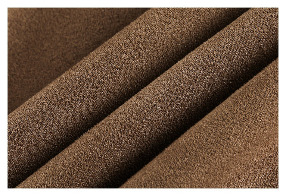 Close-up of brown fabric with a fine, nubby texture arranged in soft folds.