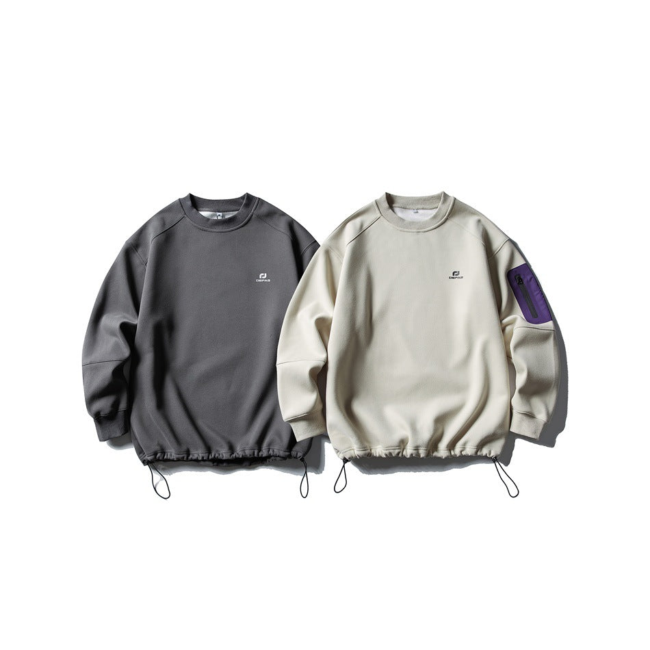 Front view of charcoal and light beige crewneck sweatshirts with chest logos, drawcord hems, and a purple sleeve pocket on