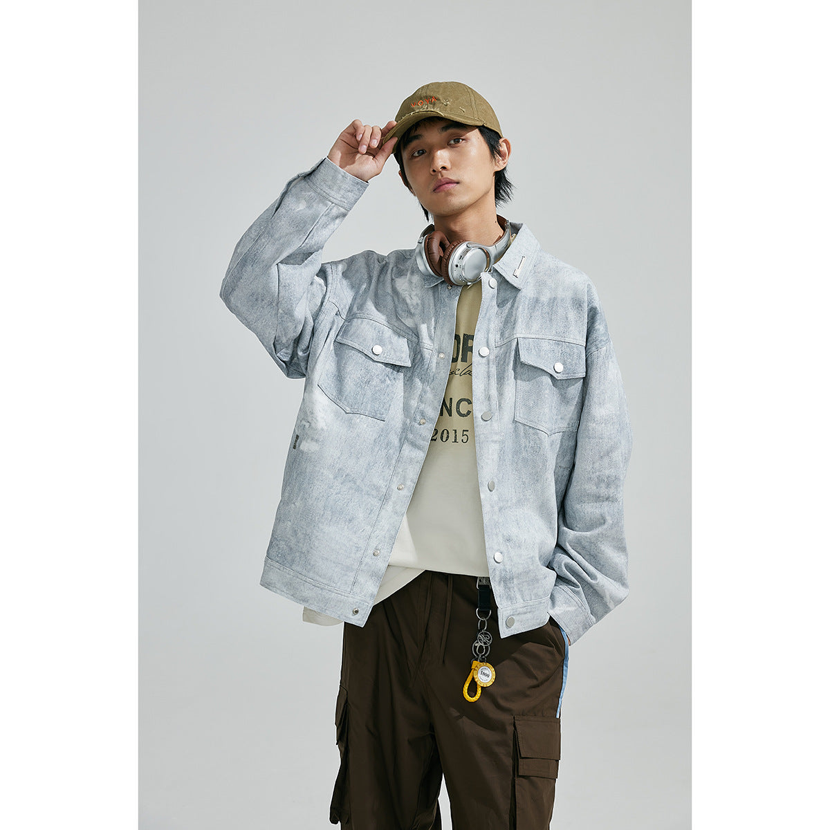 Model wearing a light gray, mottled jacket with snap buttons and two flap chest pockets, shown from the front.