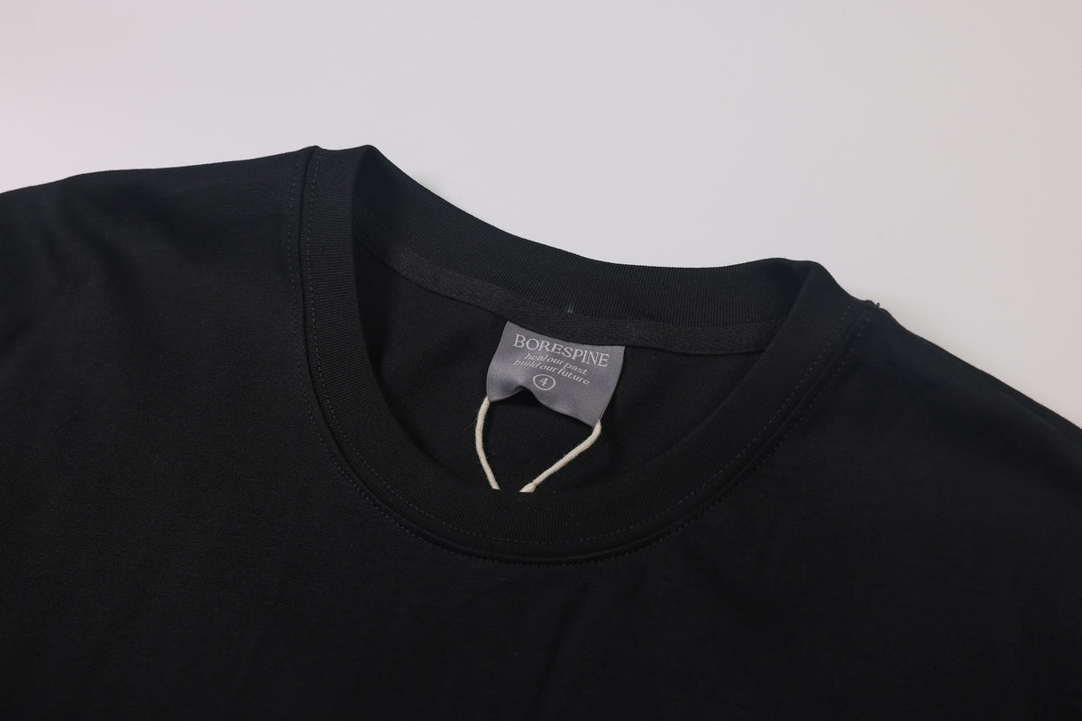Black T-shirt crew neckline with ribbed trim and a BORESPINE label, shown close up.