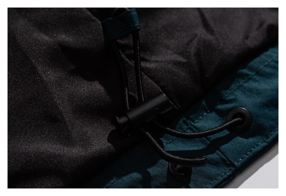 Close-up of a dark teal and black garment drawcord, eyelets, and cord lock.
