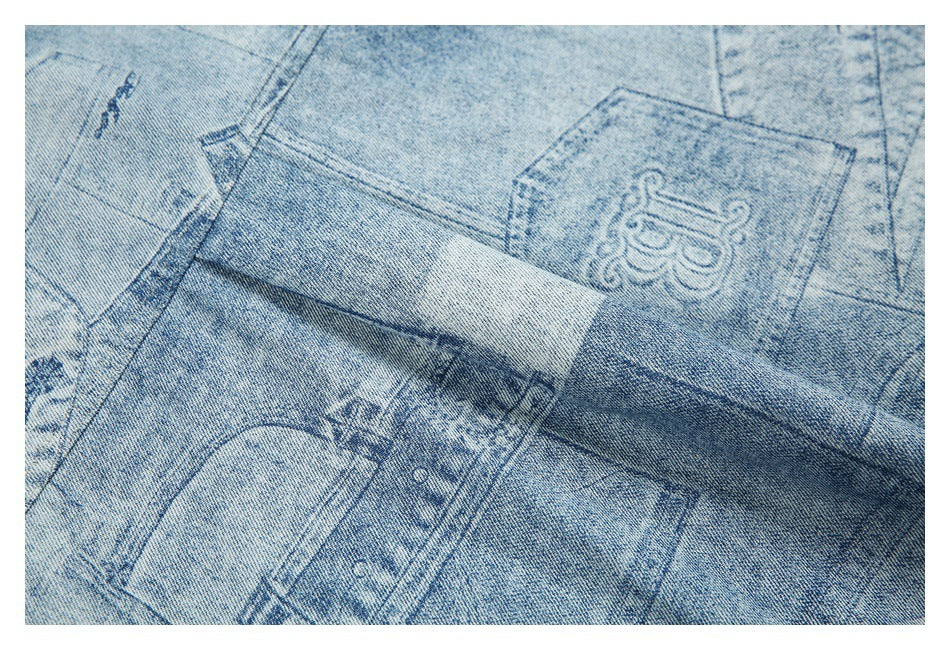 Close-up of a denim pocket and layered seams with distressed printed graphics in light and dark blue.
