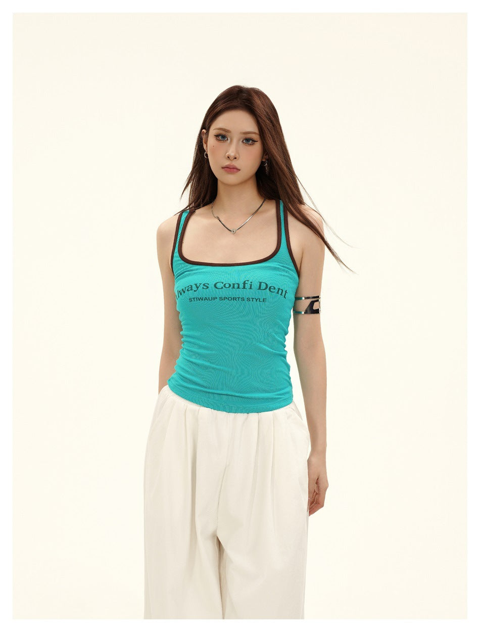 Close-up of model wearing lake blue tank top with brown neckline trim and arched chest print with white pants