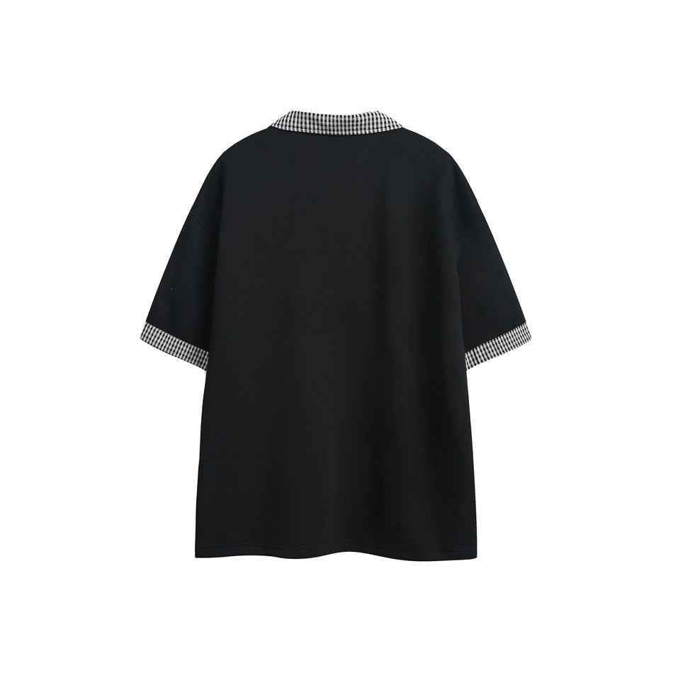 Back view of a loose black short-sleeve shirt with black-and-white gingham collar and cuffs.