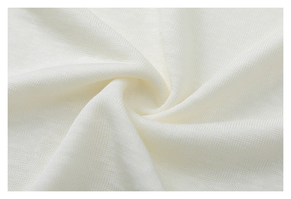 Close-up of softly draped ivory knit fabric with a fine visible texture.