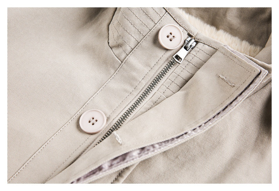 Close-up of beige garment closure with a metal zipper and two pale buttons.