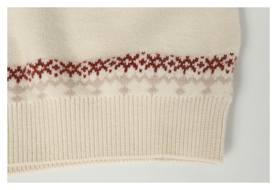 Close-up of a cream sweater hem with ribbed trim and a red and gray patterned band.