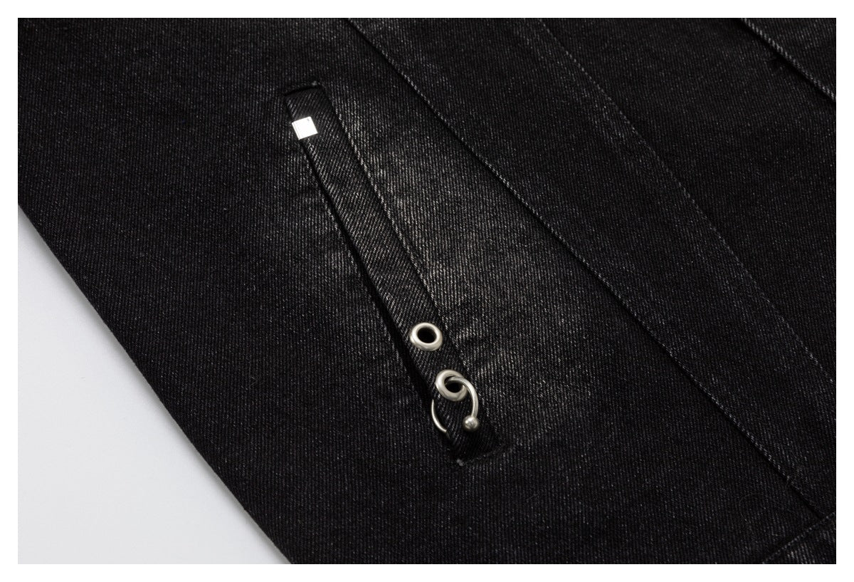 Close-up of a narrow black denim strap with silver eyelet and hook hardware.