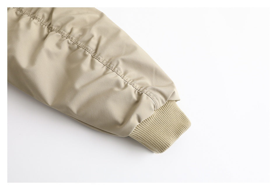 Close-up of a beige jacket sleeve ending in a ribbed cuff.