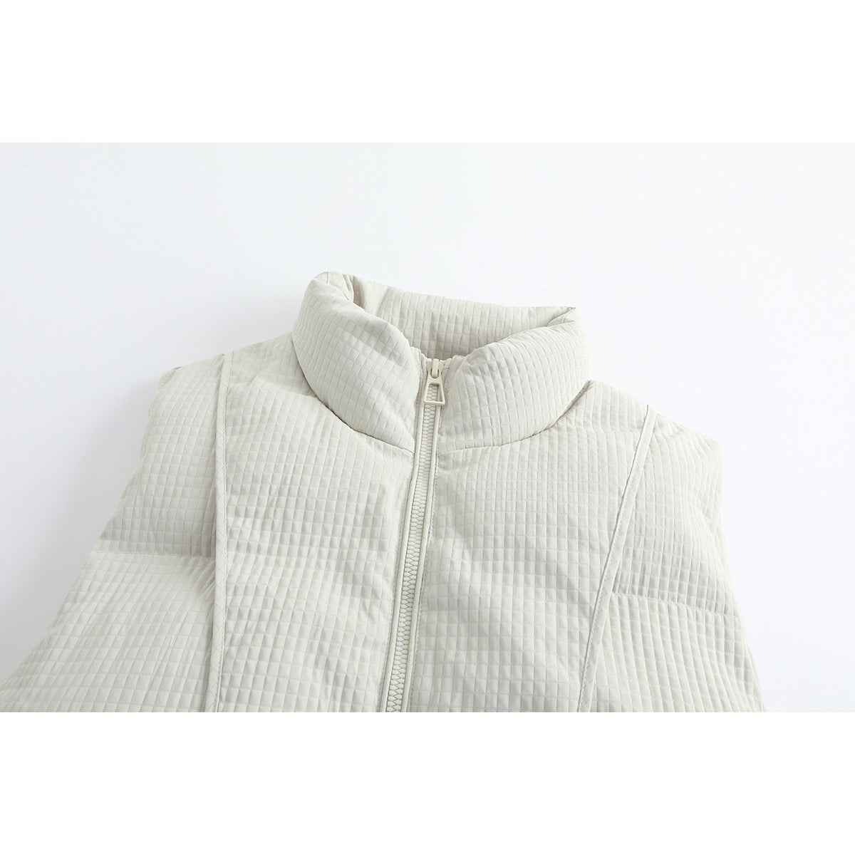 Close-up of an ivory quilted jacket with a tall padded collar and centered zipper.