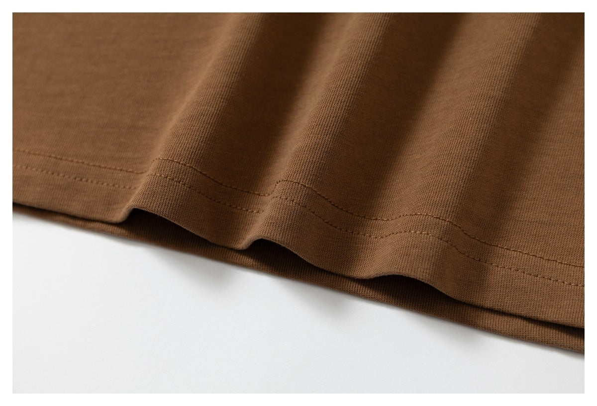 Close-up of the double-stitched hem on a brown T-shirt, showing the fabric folds.