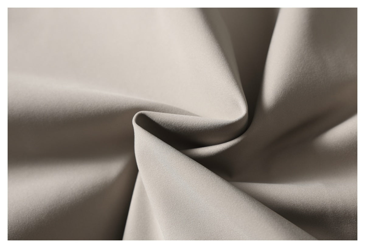 Close-up of smooth light taupe fabric arranged in soft folds.
