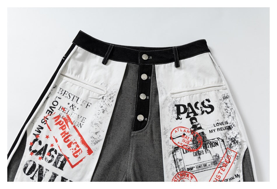 Close-up of the jeans' front waistband, button fly, and white panels with distressed black and red graphic text.