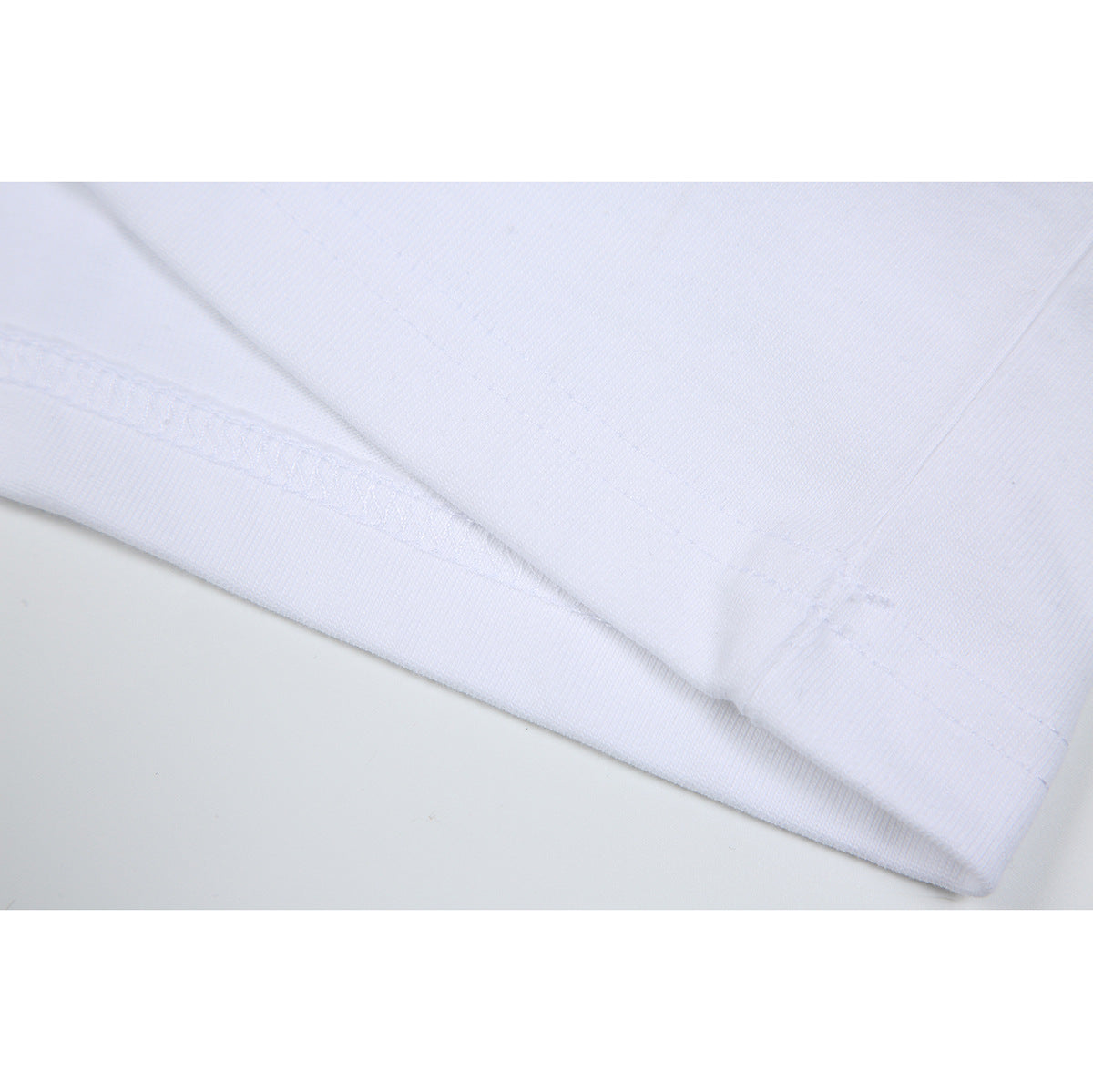 Close-up of white fabric showing a folded edge and stitched seam.