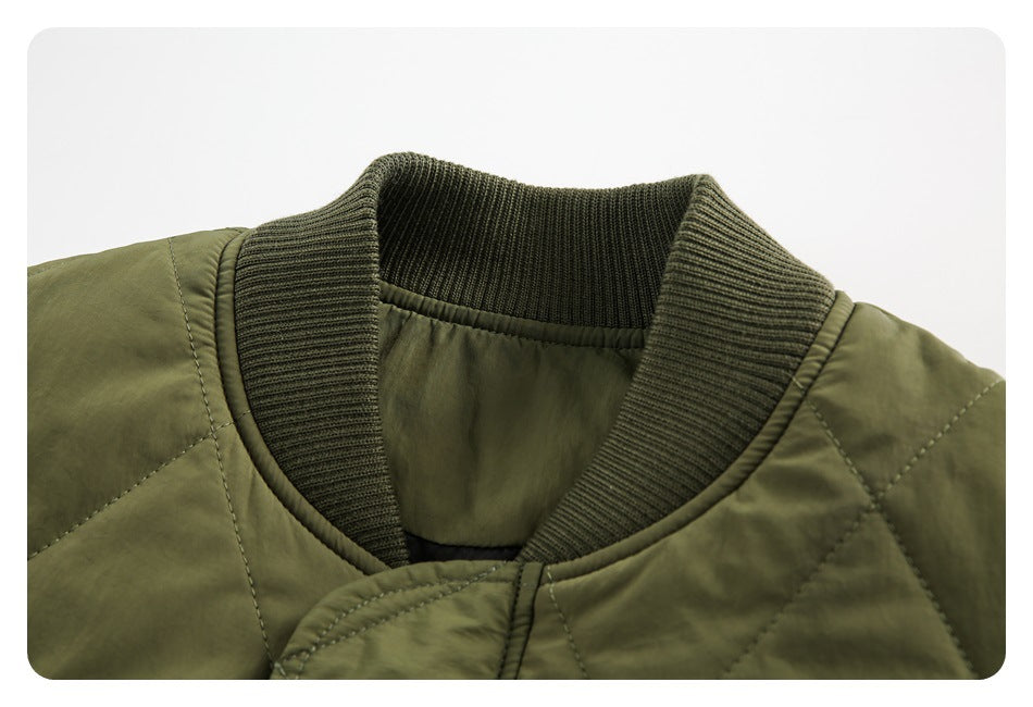 Close-up of the bomber jacket's dark olive ribbed collar, quilted shoulder, and front placket.