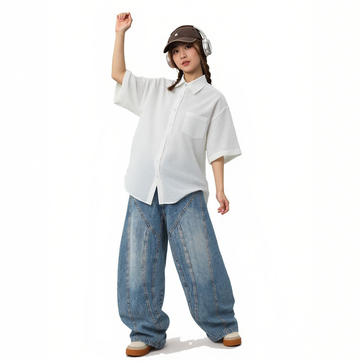 Model wearing a white textured short-sleeve button-up shirt with a chest pocket and wide-leg jeans.