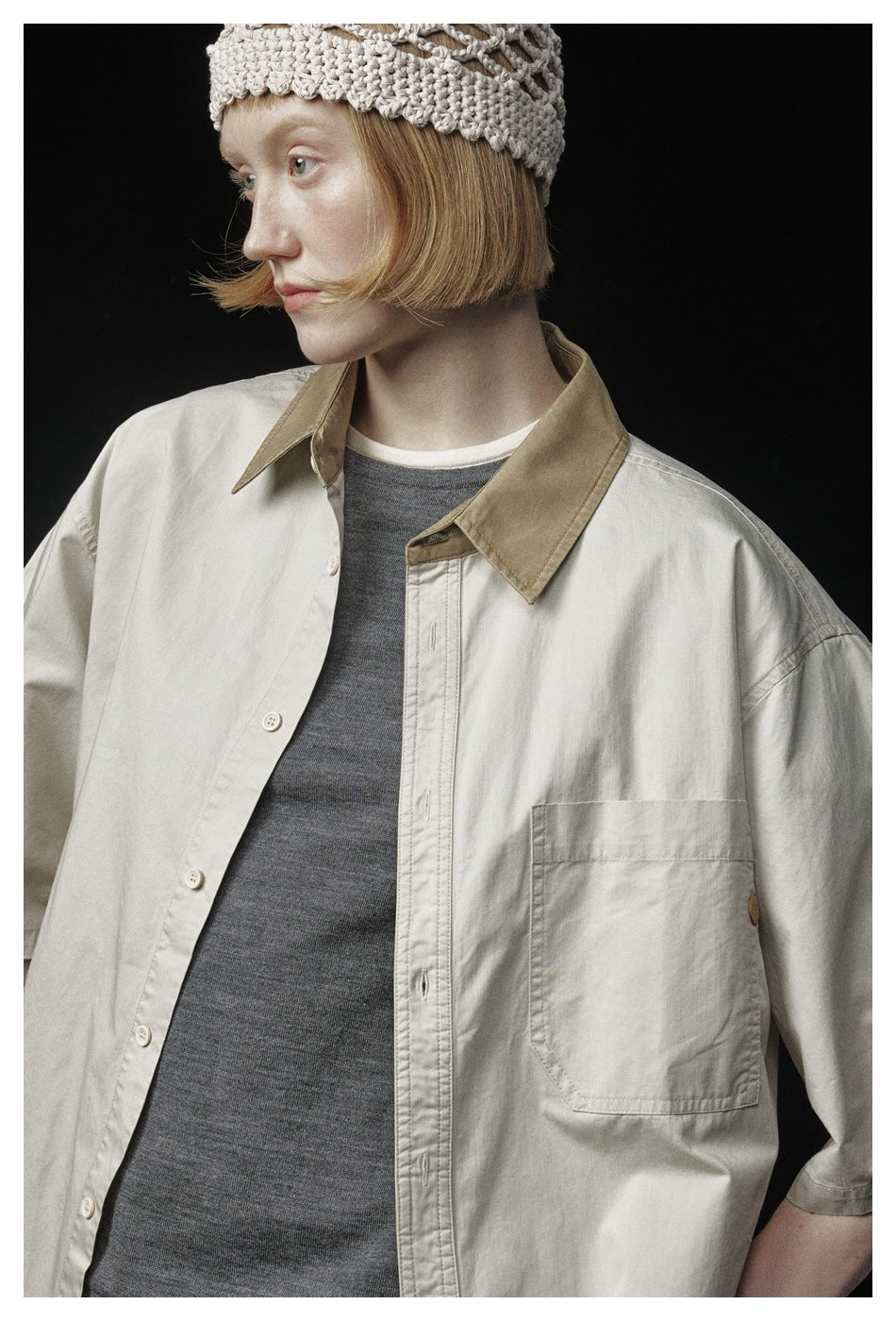 Close-up of the cream shirt's tan collar, button placket, chest pocket and short sleeve.