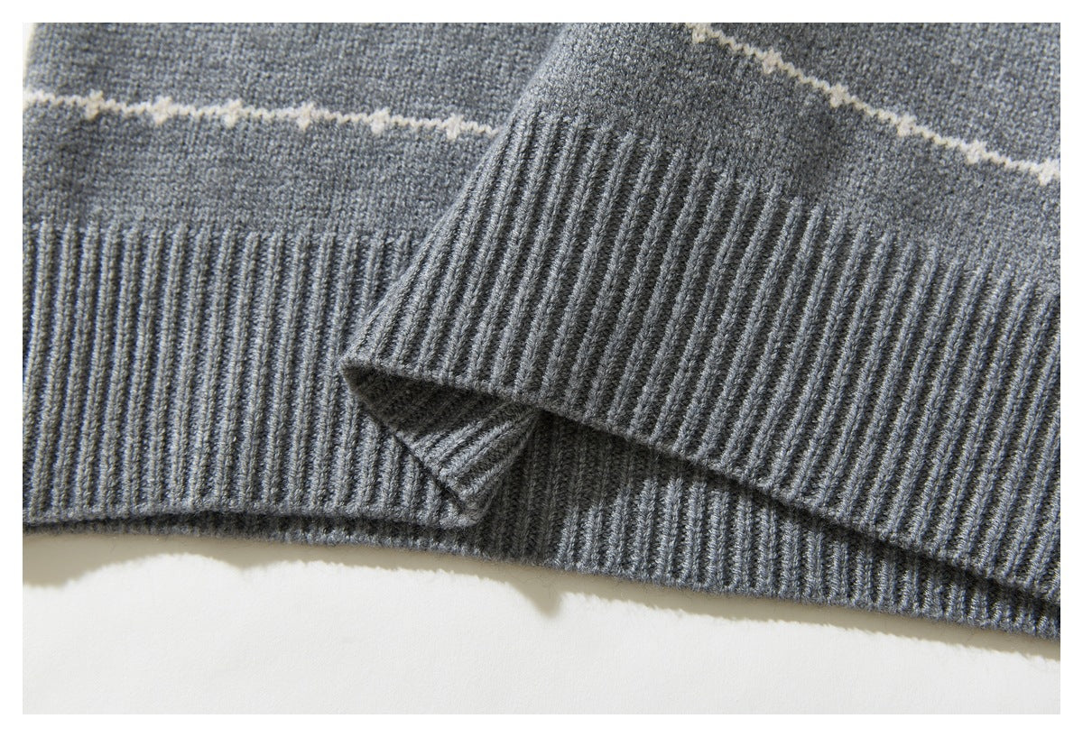 Close-up of the gray sweater’s ribbed hem and cuff, with a cream stripe across the knit.